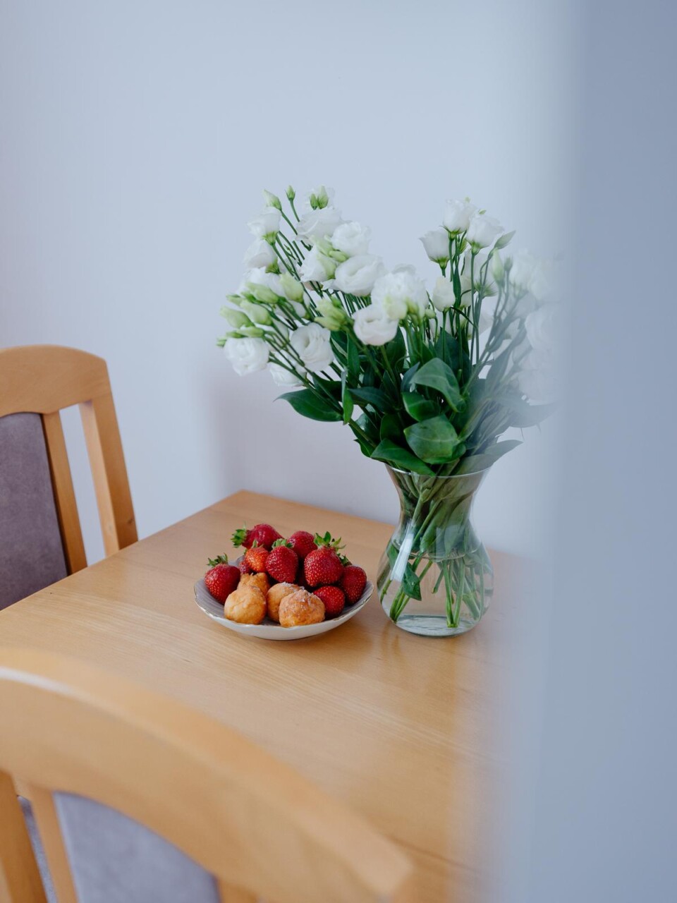 Detal pokoju: stolik z owocami i bukietem kwiatów