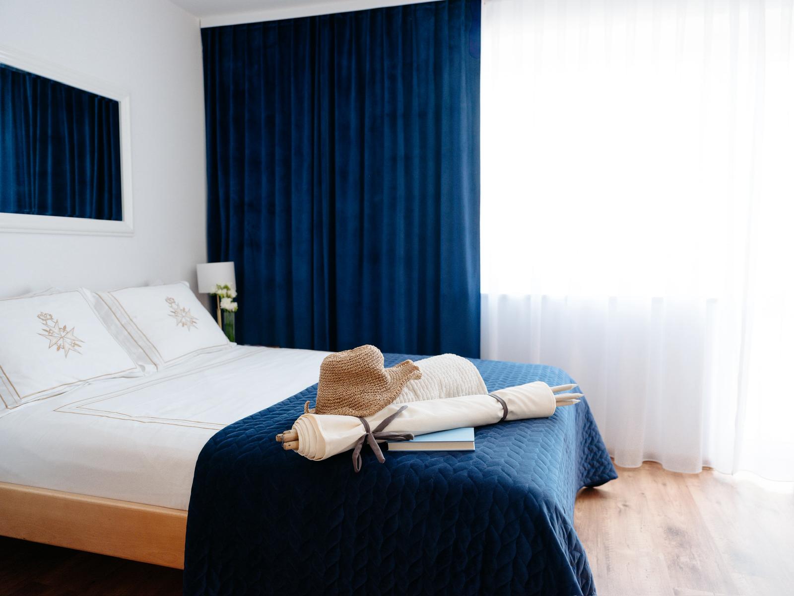 Pokój z niebieskimi zasłonami i łóżkiem małżeńskim
