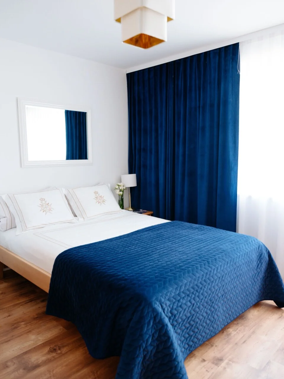 Łóżko z niebieską narzutą – ujęcie z przodu