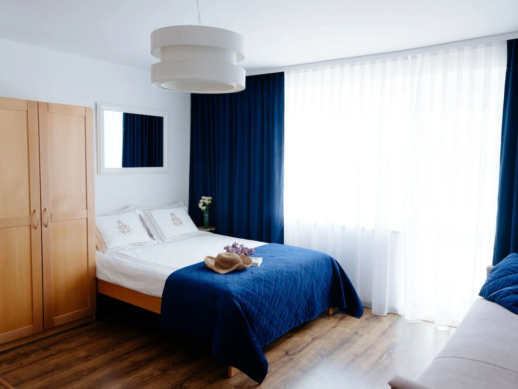 Łóżko z niebieską narzutą – ujęcie szersze