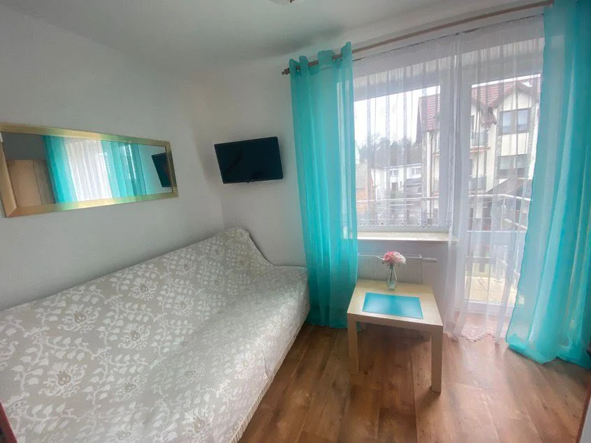 Sofa, telewizor i balkon z pokoju